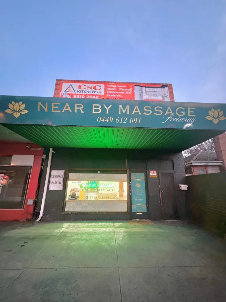 The real Footscray shopfront — green awning reading NEAR BY MASSAGE Footscray with the gold lotus mark and phone number painted on